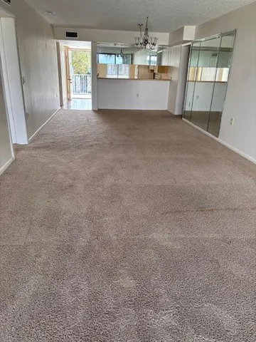 an empty room with windows and chandelier