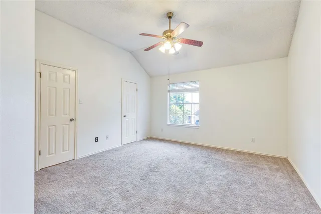 an empty room with a window and a fan
