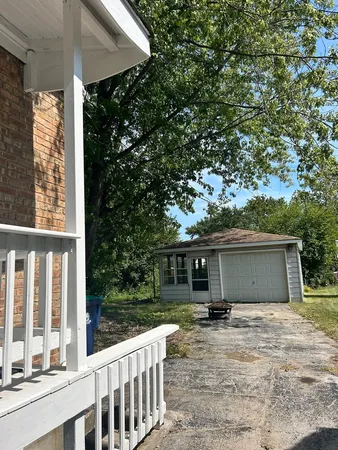 a backyard of a house with table and chairs under an umbrella