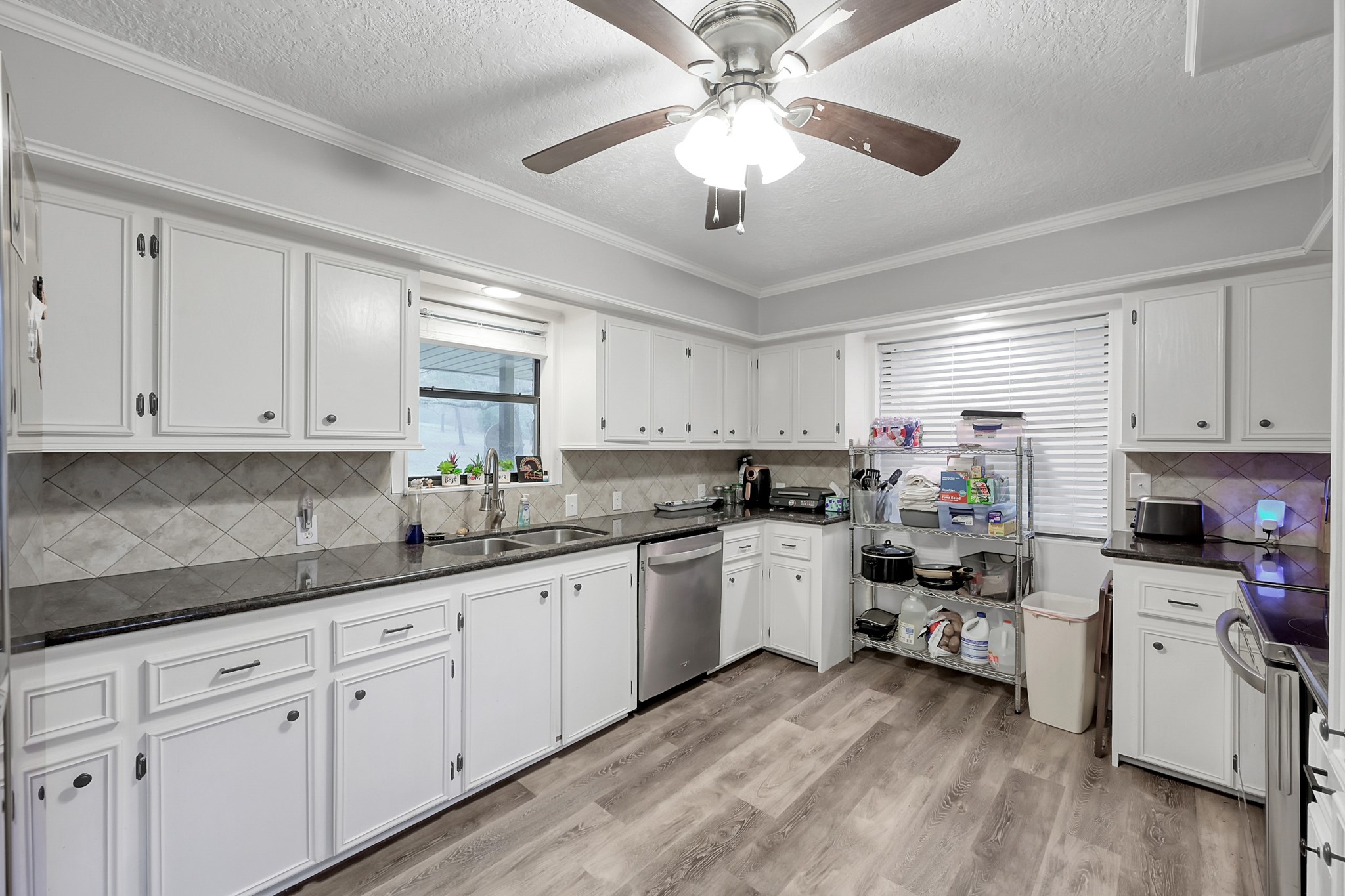 80 Nettie Phillips Road Coldspring, TX 77331 - Photo 11 of 49 Newly painted Kitchen cabinets with granite countertops and tile backsplash. Large window highlights the outdoor space.