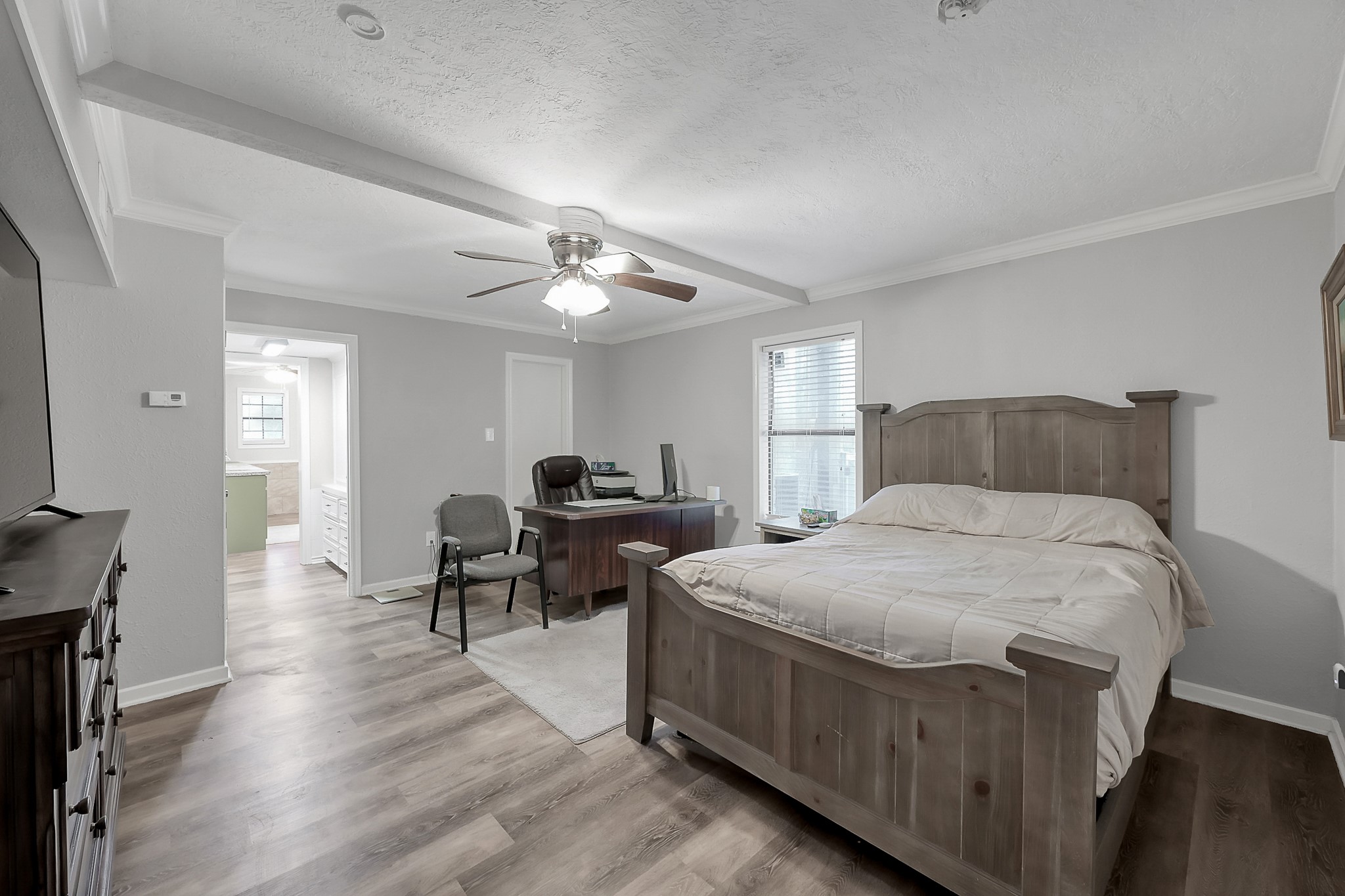 80 Nettie Phillips Road Coldspring, TX 77331 - Photo 15 of 49 Downstairs Primary Suite with crown molding and ceiling fan. Could be used as a Home Office/Study with full bath.