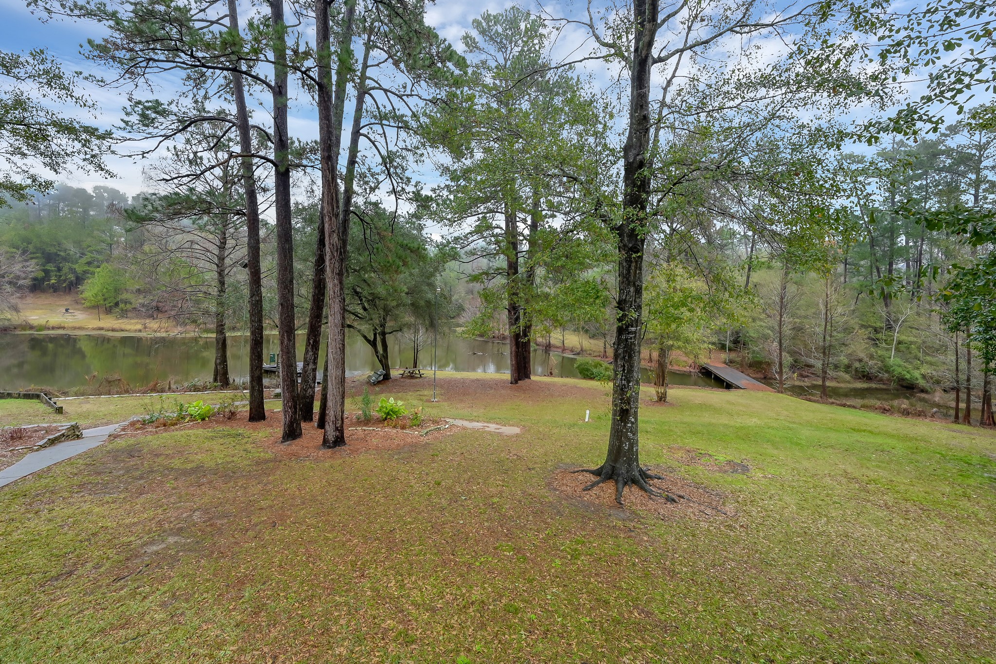 80 Nettie Phillips Road Coldspring, TX 77331 - Photo 33 of 49 One of two stocked ponds with bridge to a cleared pathway.