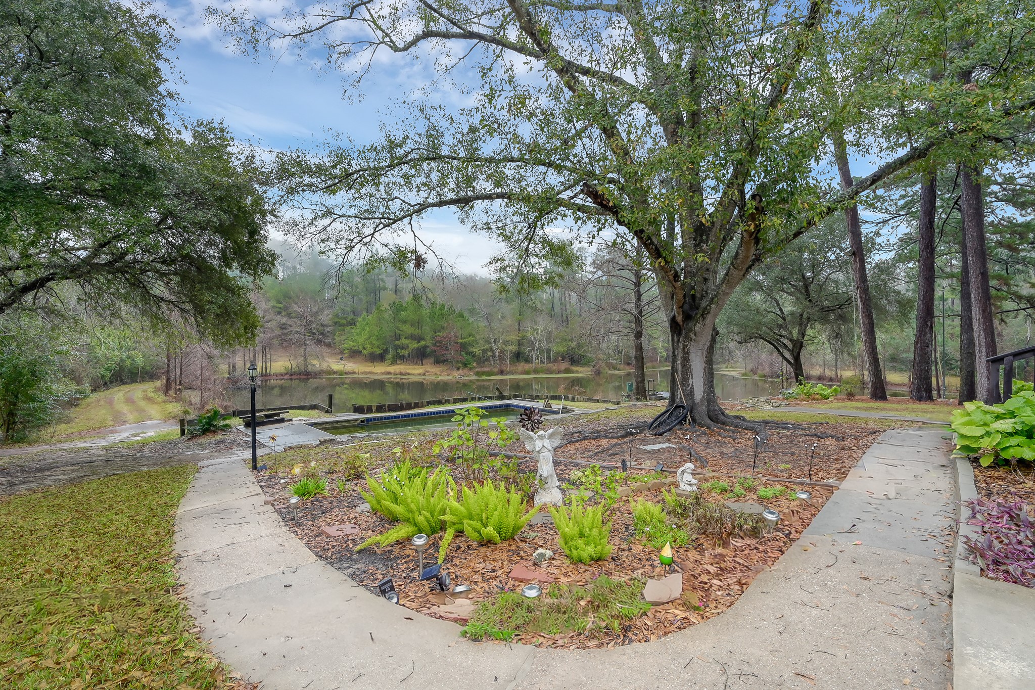 80 Nettie Phillips Road Coldspring, TX 77331 - Photo 35 of 49 Concrete pathway leads from the covered patio to the pool area, then down to the dock.
