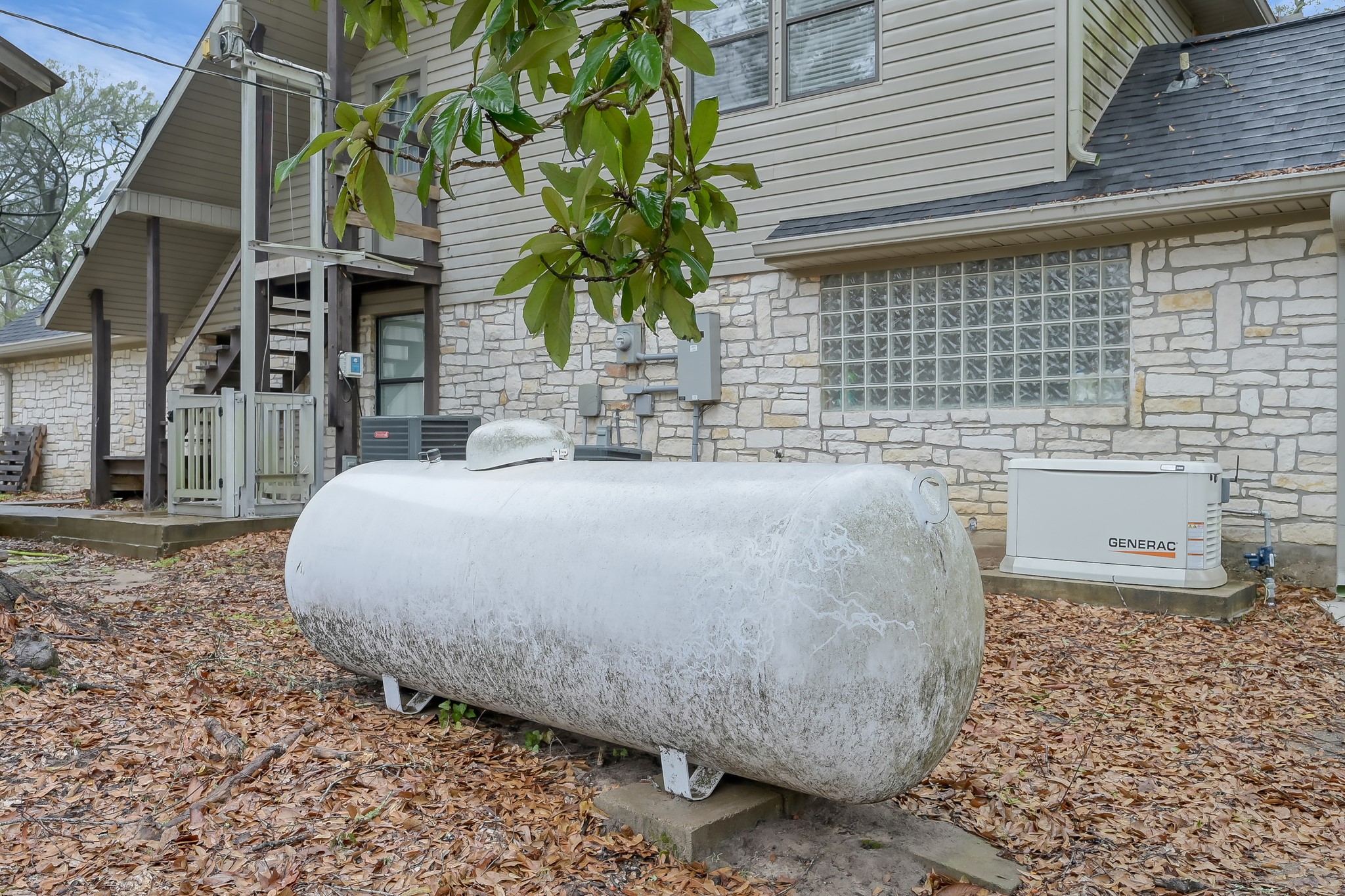 80 Nettie Phillips Road Coldspring, TX 77331 - Photo 43 of 49 Exterior elevator to the left, two AC units, generator and propane tank all conveniently accessible.