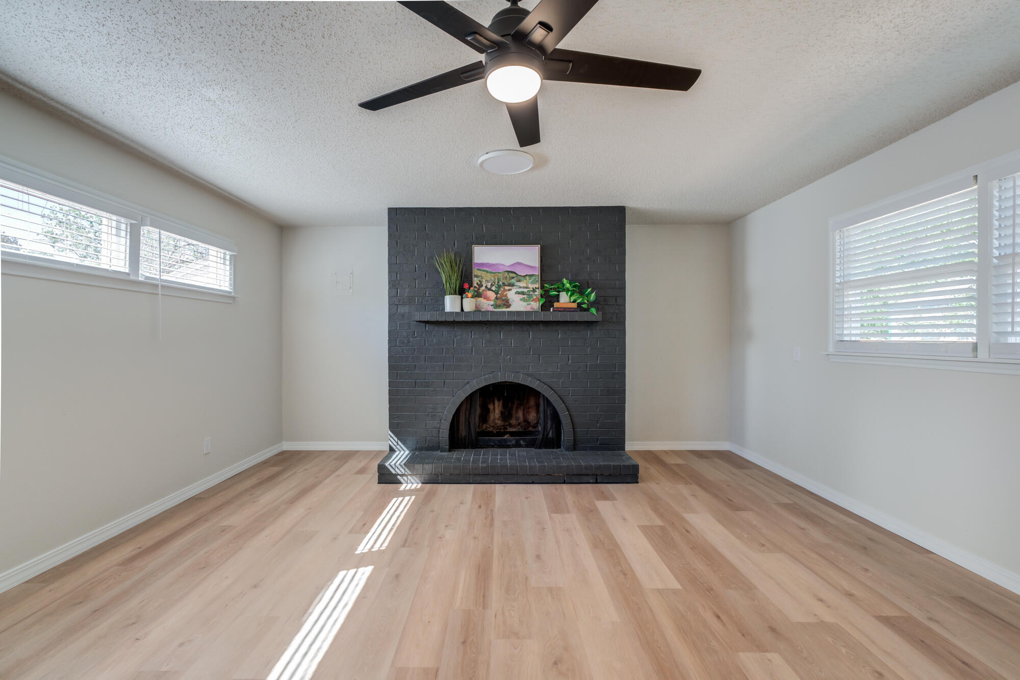 3610 30th Street Lubbock, TX 79410 - Photo 25 of 35 a living room with a fireplace and a ceiling fan
