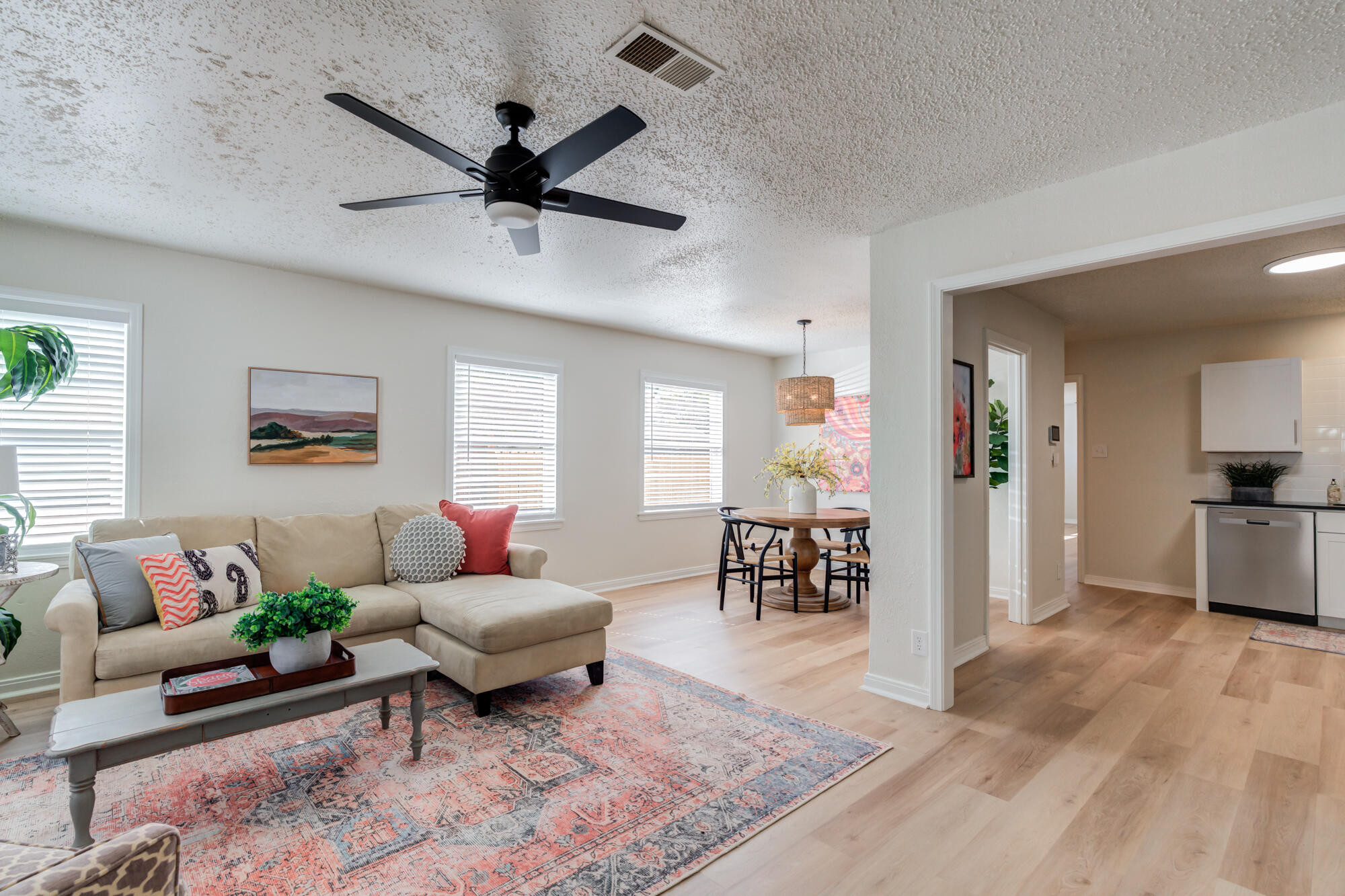 3610 30th Street Lubbock, TX 79410 - Photo 5 of 35 a living room with furniture and a dining table with wooden floor