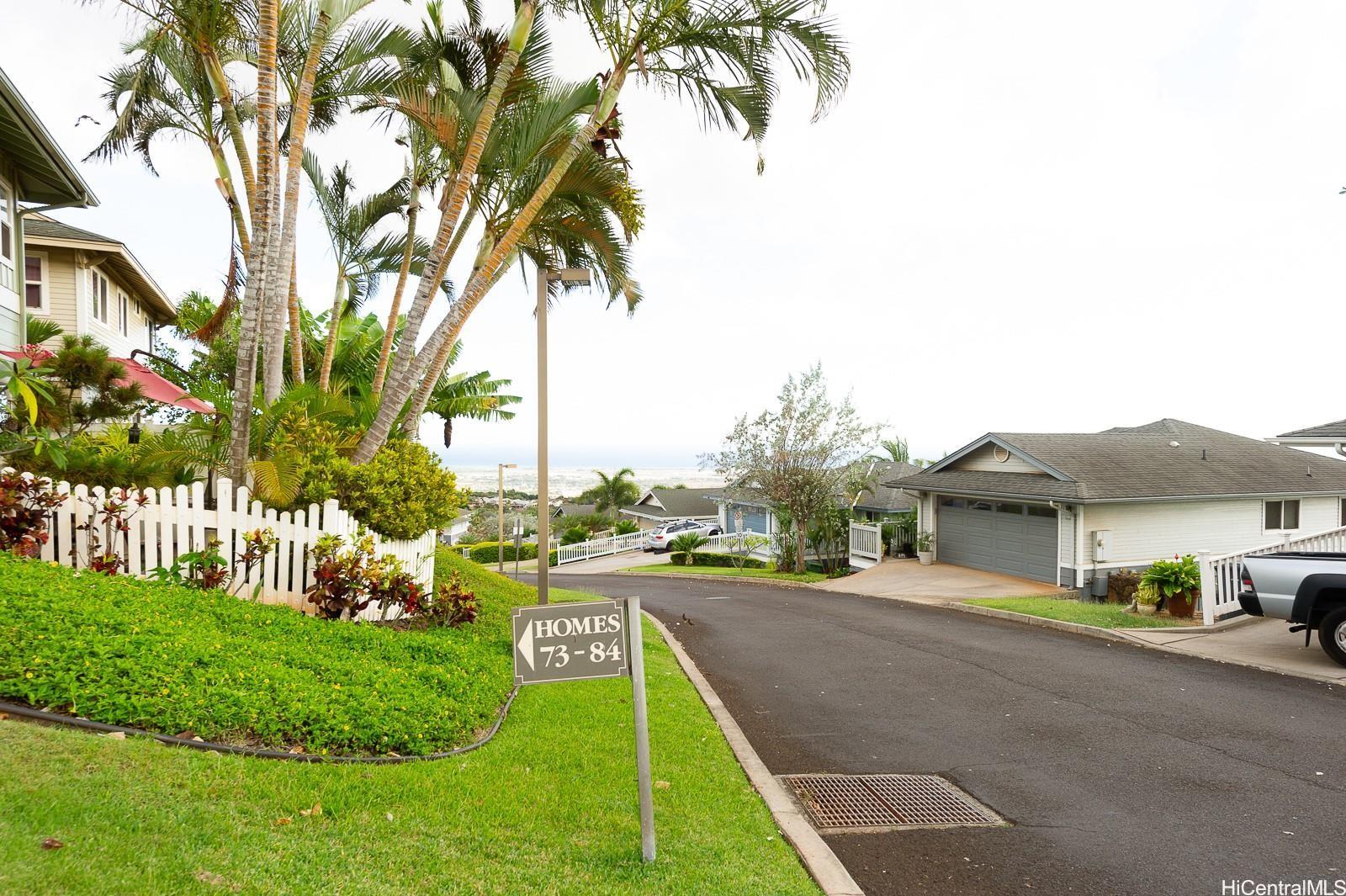 92-7049 Elele Street, Unit 81 Kapolei, HI 96707 - Photo 19 of 21 a view of a house with a yard and palm trees