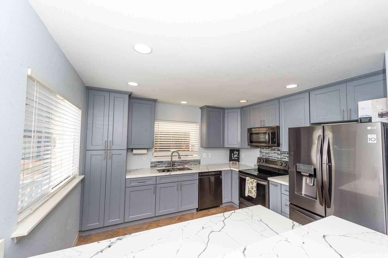 92-7049 Elele Street, Unit 81 Kapolei, HI 96707 - Photo 9 of 21 a kitchen with stainless steel appliances kitchen island granite countertop a refrigerator sink and cabinets