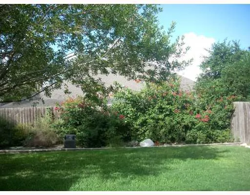 a view of grassy field with trees in the background