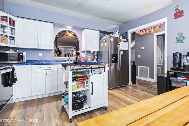 a view of a kitchen with cabinets and wooden floor