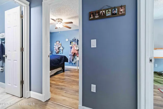 a view of a room that has a bed and a mirror in it