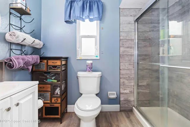 a bathroom with a sink a toilet and shower