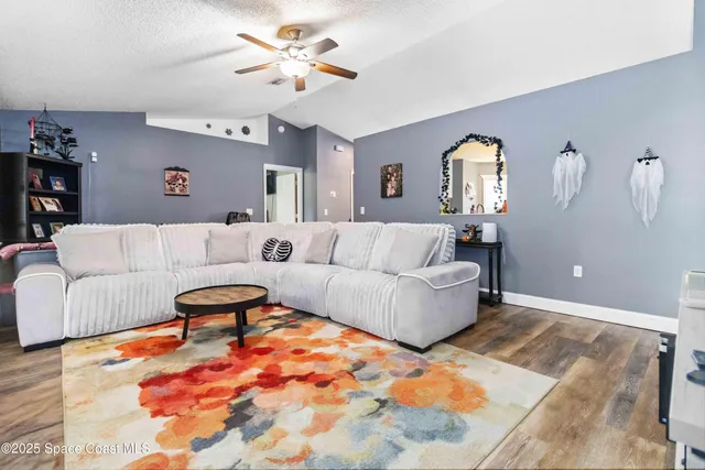a living room with furniture and a wooden floor