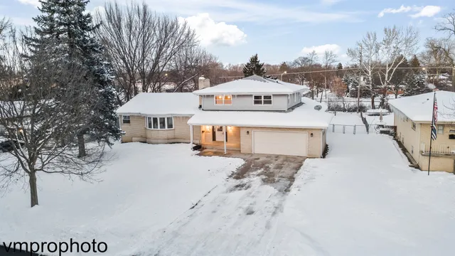 a front view of a house with a yard covered with snow in front of house