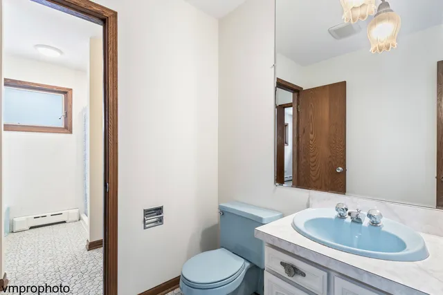 a bathroom with a sink vanity mirror and toilet