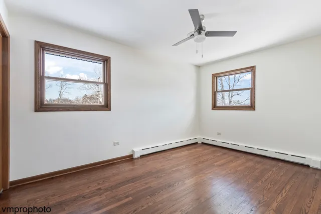 an empty room with a window and a ceiling fan