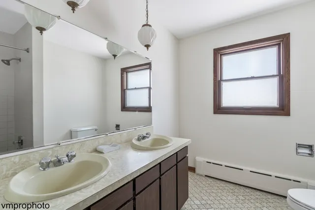 a bathroom with a sink double vanity and a toilet