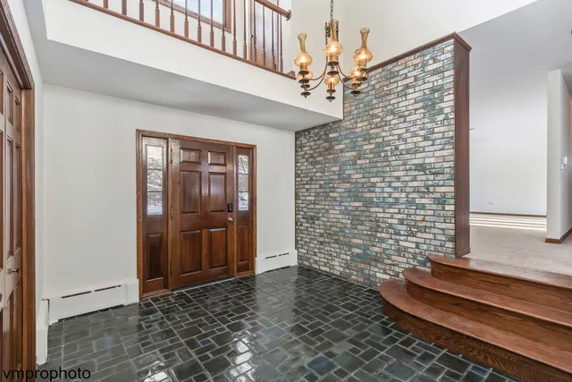 a view of a hallway with wooden floor and a chandelier