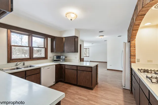 a large kitchen with stainless steel appliances granite countertop a sink stove and refrigerator