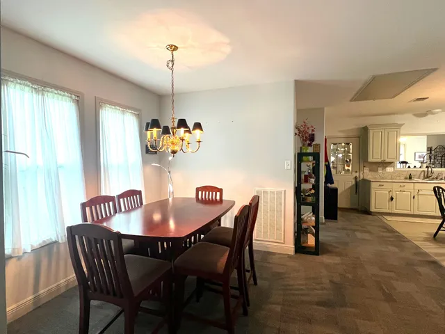 a dining room with furniture a chandelier and window