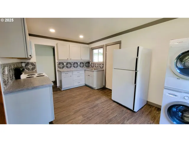 a kitchen with a refrigerator and a stove top oven