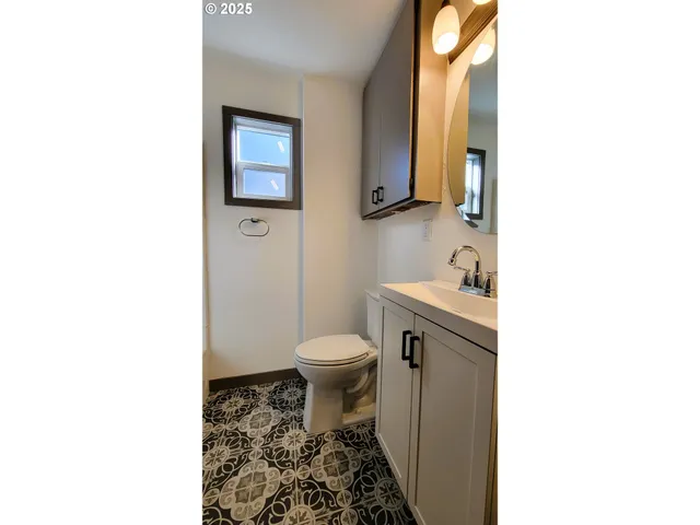 a bathroom with a toilet a sink and mirror