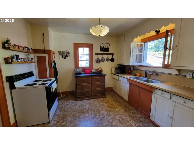 a kitchen view with wooden cabinets a sink a window and appliances