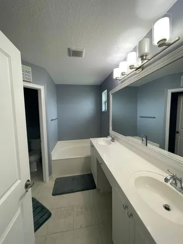 a bathroom with a tub sink and a mirror