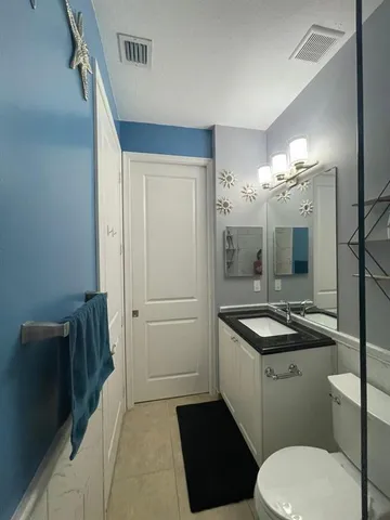a bathroom with a sink a toilet a mirror and vanity