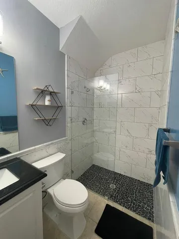 a bathroom with a toilet and a shower