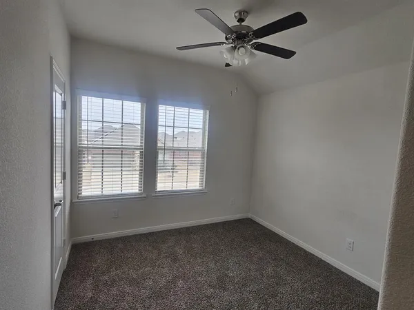 an empty room with a window and a fan
