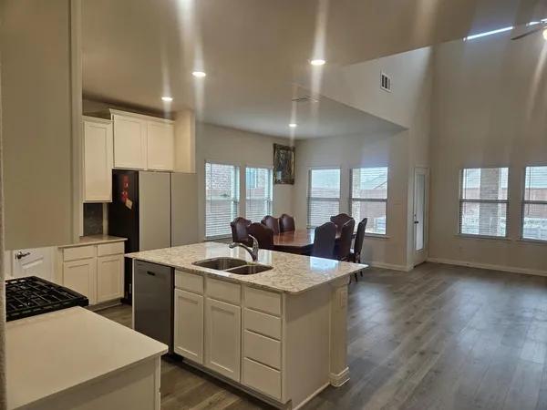 a kitchen that has a sink a stove and chairs