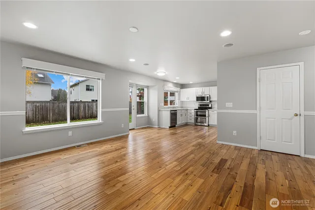 a view of a kitchen with wooden floor and a window