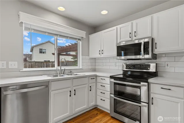 a kitchen with stainless steel appliances a stove sink and refrigerator