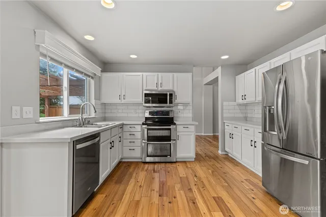 a kitchen with stainless steel appliances a refrigerator and a stove top oven