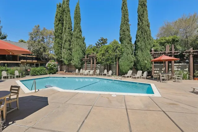 a view of pool with outdoor seating and plants