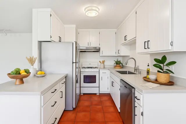 a kitchen with white cabinets and white appliances