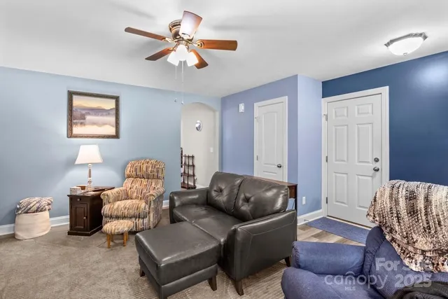 a living room with furniture and a ceiling fan