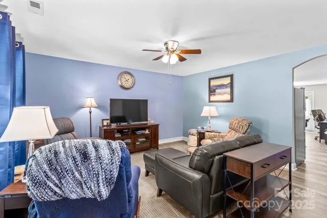 a living room with furniture a flat screen tv and a lamp