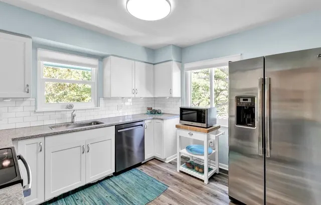a kitchen with granite countertop a sink appliances and cabinets