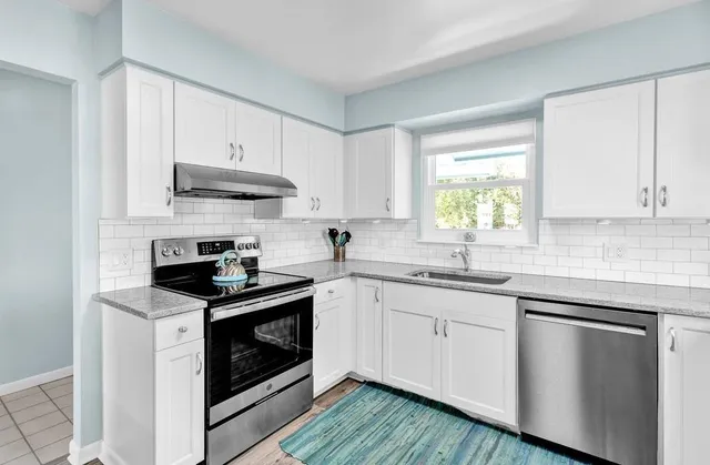 a kitchen with stainless steel appliances granite countertop a sink stove and cabinets