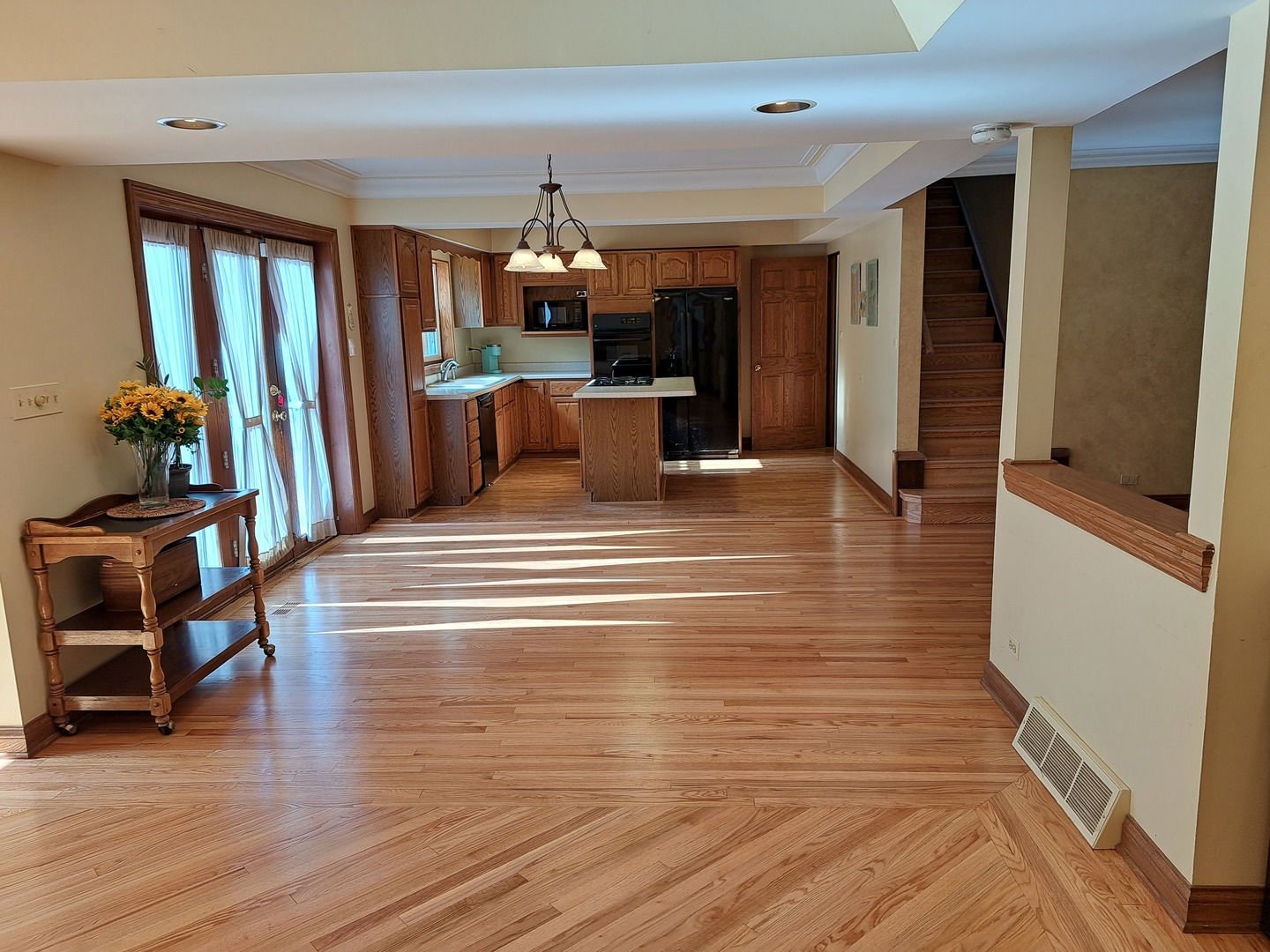 Undisclosed Address Park Ridge, IL 60068 - Photo 8 of 25 a view of a living room and kitchen with furniture wooden floor and a ceiling fan