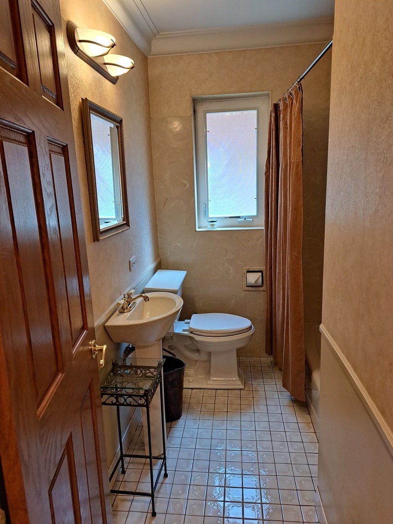 Undisclosed Address Park Ridge, IL 60068 - Photo 9 of 25 a bathroom with a sink a toilet and mirror
