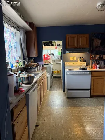 a kitchen with stainless steel appliances a stove top oven a sink a counter top space and cabinets