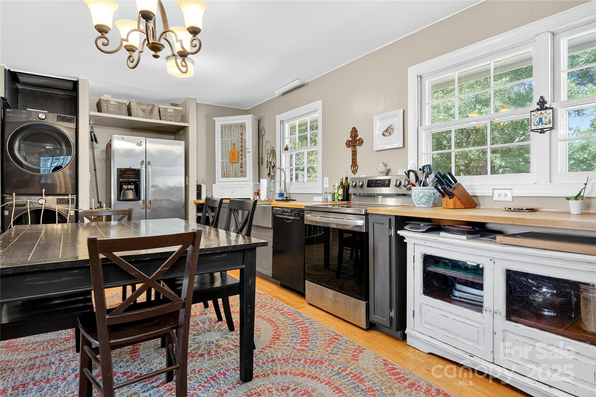205 Airport Road Monroe, NC 28110 - Photo 15 of 32 a open kitchen with stainless steel appliances granite countertop a stove a sink dishwasher a dining table and chairs with wooden floor