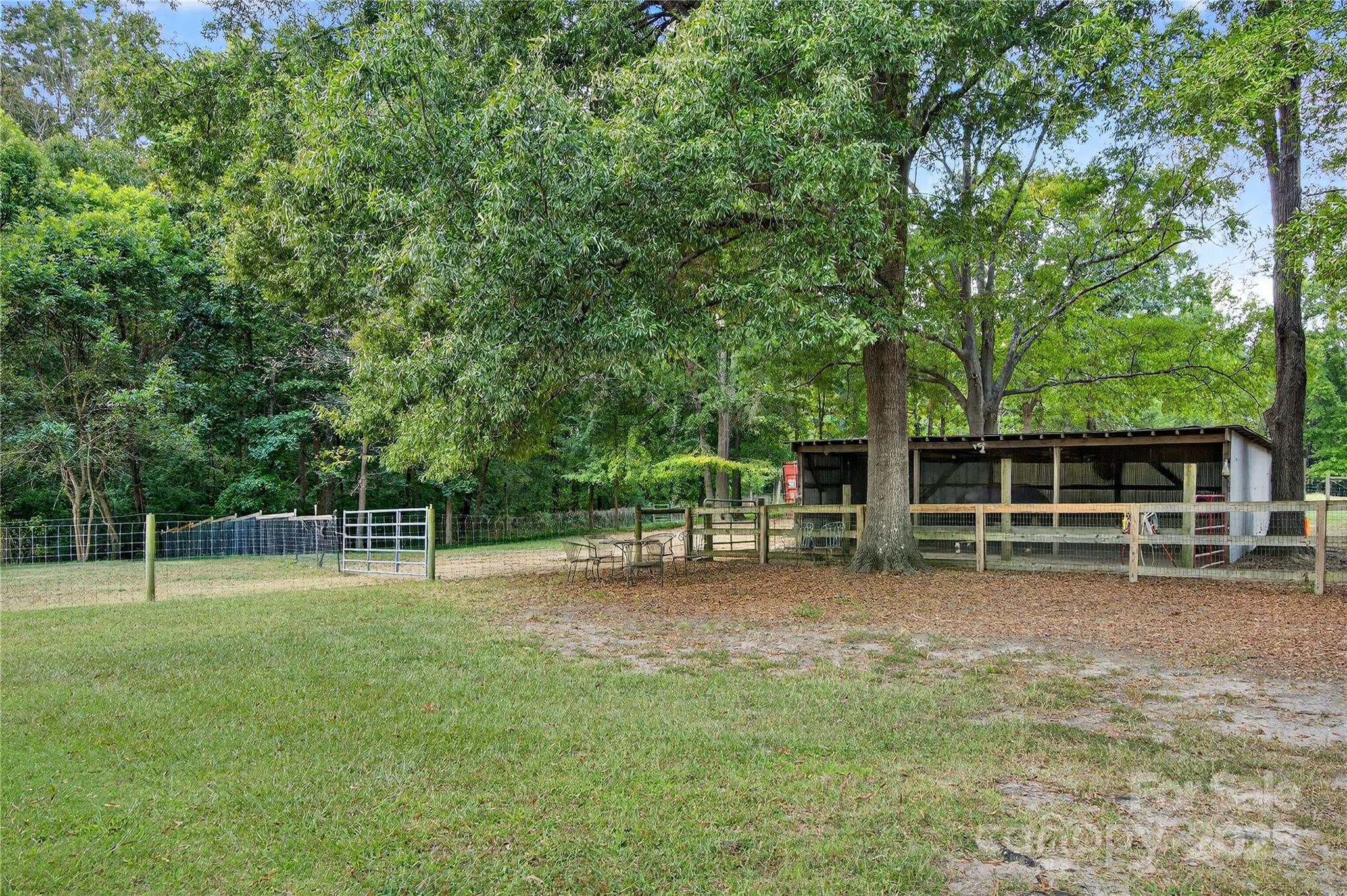 205 Airport Road Monroe, NC 28110 - Photo 2 of 32 a view of a backyard with wooden fence and a tree