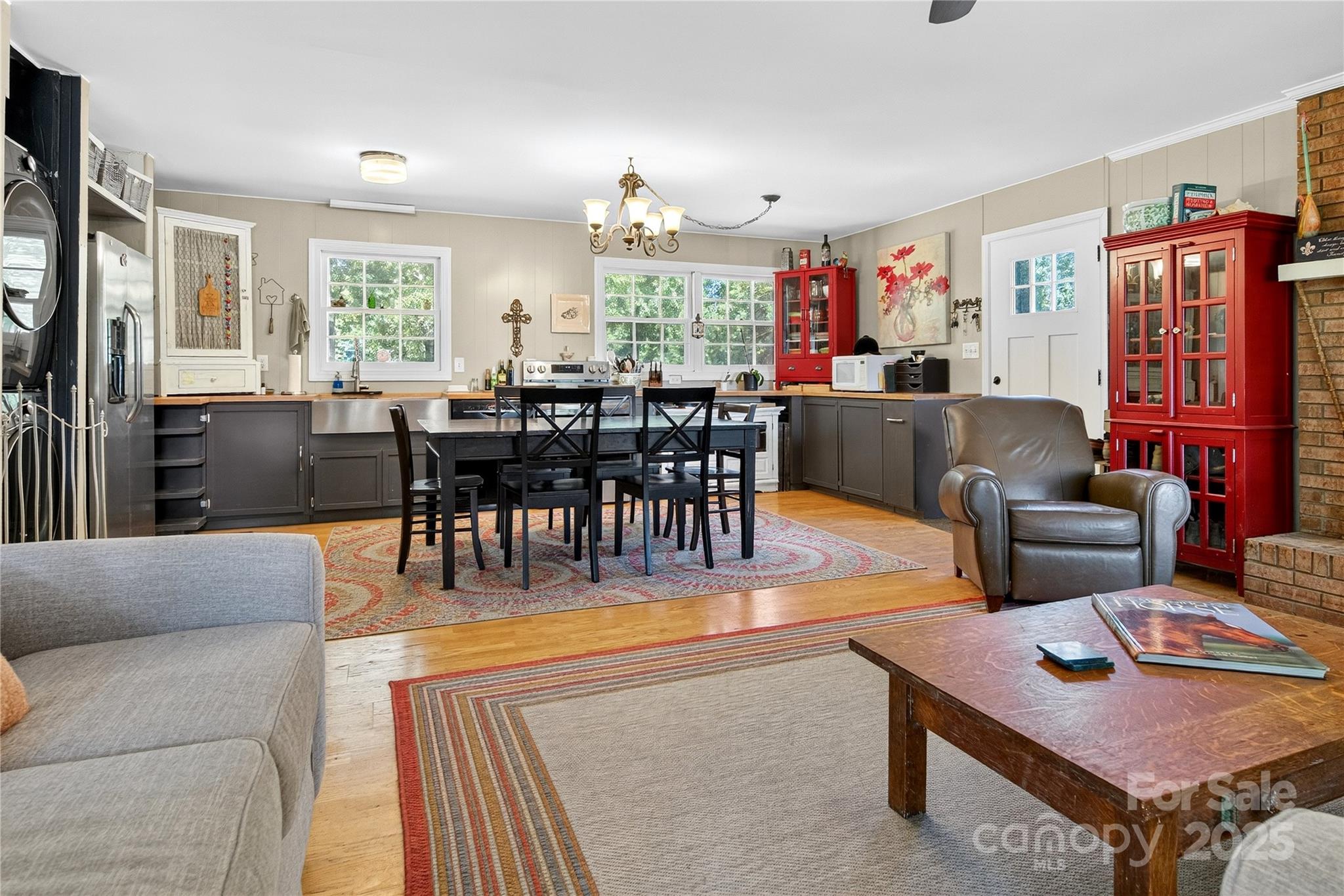 205 Airport Road Monroe, NC 28110 - Photo 27 of 32 a living room with furniture a dining table and a chandelier