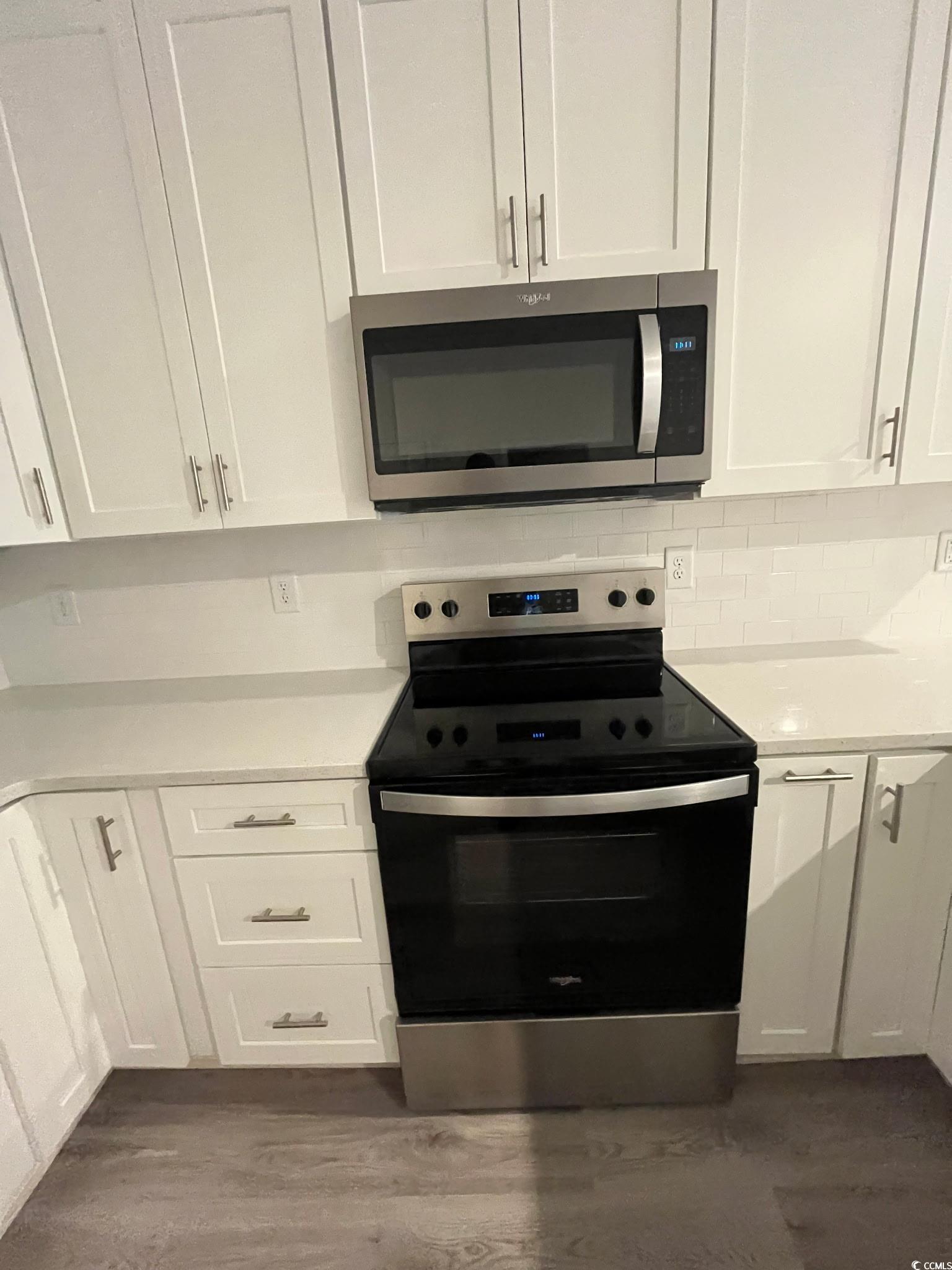 1505 1st Avenue Conway, SC 29526 - Photo 9 of 9 Kitchen featuring appliances with stainless steel finishes, tasteful backsplash, white cabinets, and dark wood finished floors
