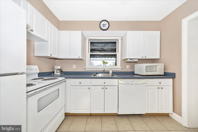 a kitchen with a refrigerator sink and cabinets