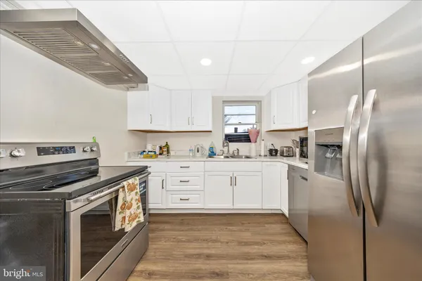 a kitchen with a refrigerator and white cabinets